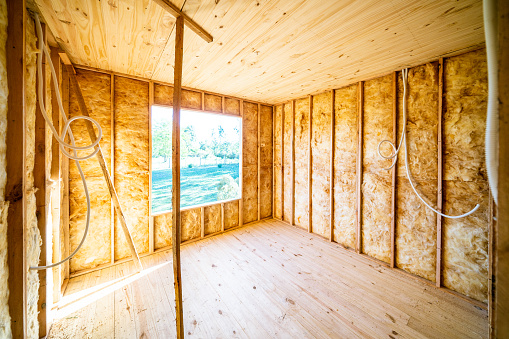 Wooden house construction site interior during wall insulation, ready for drywall installation