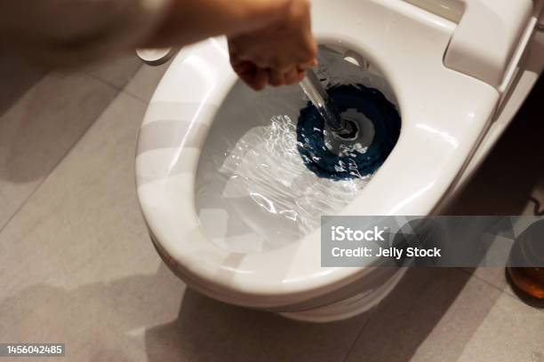 Unclog A Toilet With Plunger Stock Photo - Download Image Now - Toilet, Clogged, Public Restroom