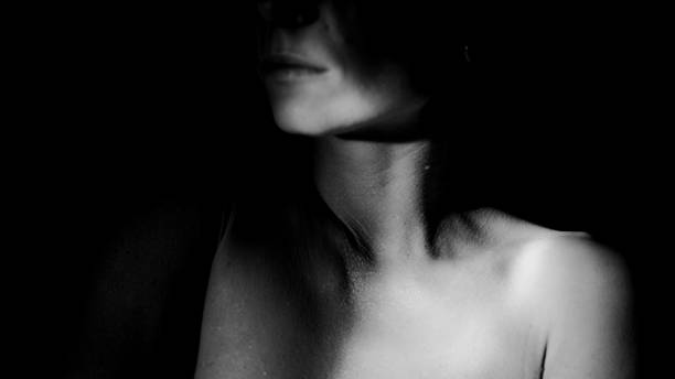 istock Female body and face in light. 1456042554