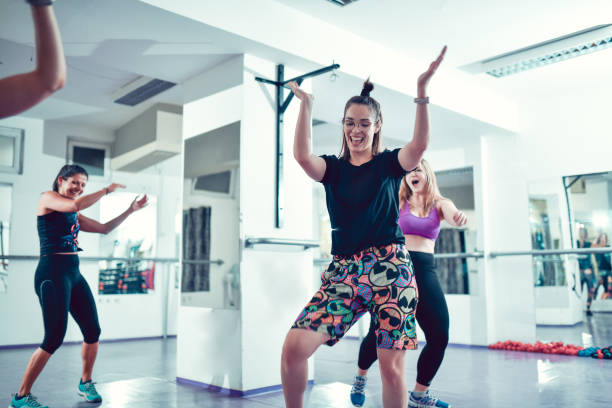 istock Smiling Female Enjoying Dance Workout With Other Athletes In Gym 1456044109