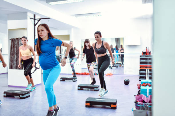 istock Front View Of Athletic Females Using Stepper Exercises In Gym 1456045405