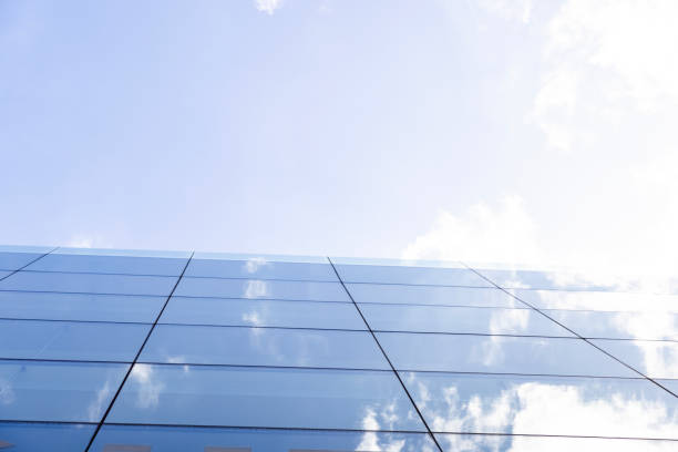 Closeup glass wall of office building with reflection of sky, background with copy space, full frame horizontal composition