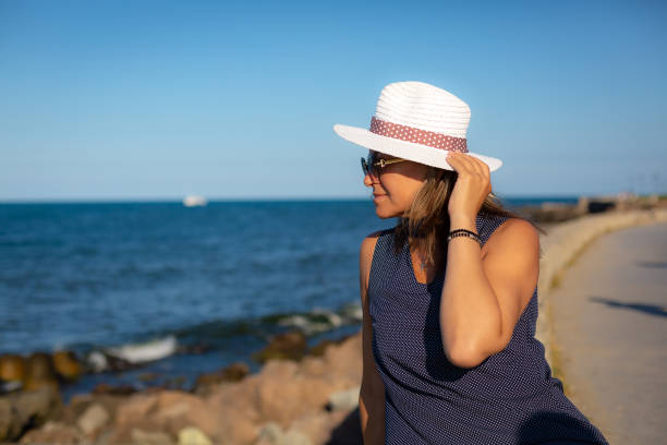 istock Woman watching sunset by the sea 1456046902