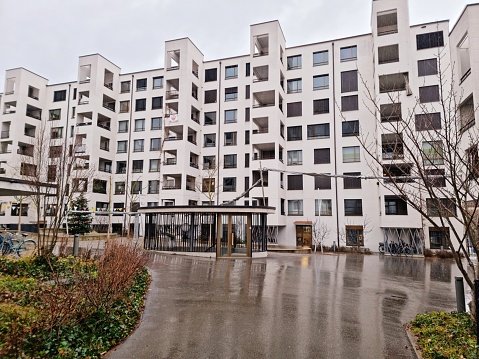 Triemli 1 Zurich is a residential complex planned by  Hauenstein La Roche Schedler Architects (HLS). The buildings have been completed in 2017. Triemli 1 includes 167 apartments and 6 commercial premises. The Image was captured during winter season on a rainy day.