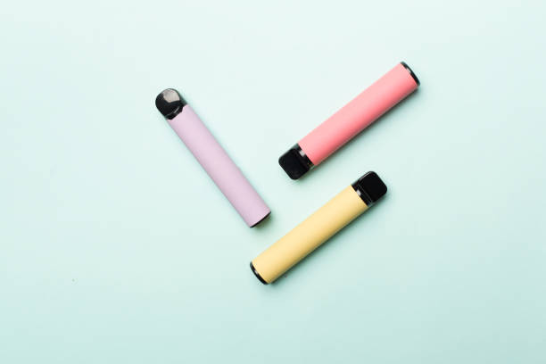 istock Disposable electronic cigarettes on color background, top view 1456048591