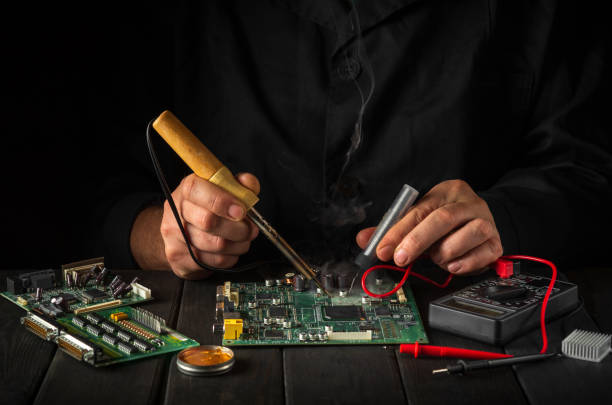 istock Repair of computers or electronics by a foreman in a workshop. Computer repair service by a specialist in a workshop 1456050160