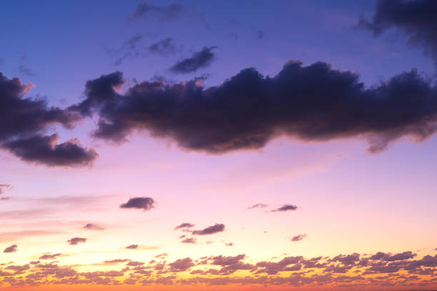 Mostly blue clouds with area of warmth at bottom indicating a setting sun with warm orange colors. Suitable for sky replacements and background.