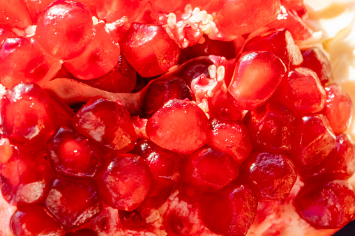 Close up of fresh harvested juicy and ripe pomegranate seeds placed on a outdoors fruit market, close up. Vibrant colors. Photography, top view. Organic food background with copy space.