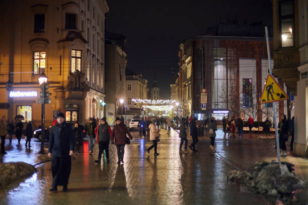 クリスマスの間にクラクフの路上で夕方の人々。 - florianska street ストックフォトと画像