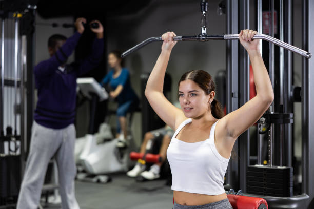 istock Caucasian woman training on lat pull down machine in gym 1456057798