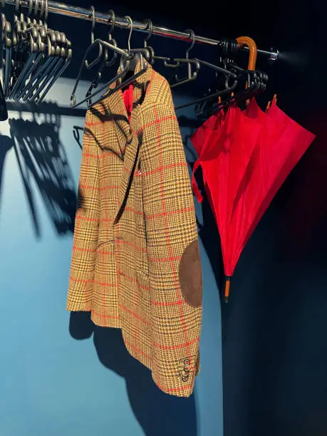 Hanger with plaid jacket and red umbrella hanging on it