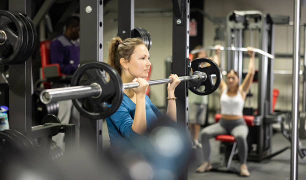istock Athletic woman doing barbell exercises in gym 1456059997
