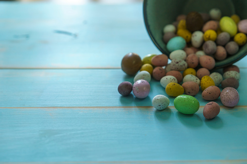 Easter Eggs on a Rustic Blue Wood Background. Hard shell candy coated chocolate easter eggs.
