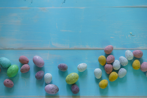 Easter Eggs on a Rustic Blue Wood Background. Hard shell candy coated chocolate easter eggs.