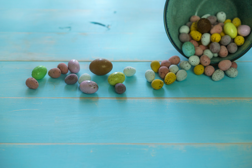 Easter Eggs on a Rustic Blue Wood Background. Hard shell candy coated chocolate easter eggs.