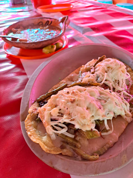 istock The huarache is a typical Mexican dish, whose shape simulates traditional Mexican sandals. It is made with corn dough, steak, or egg accompanied with sauce, cheese, and beans 1456060772