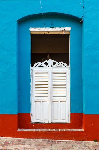 Blue colonial house with an ornate white wooden door in the old center of Trinidad, Cuba, Caribbean