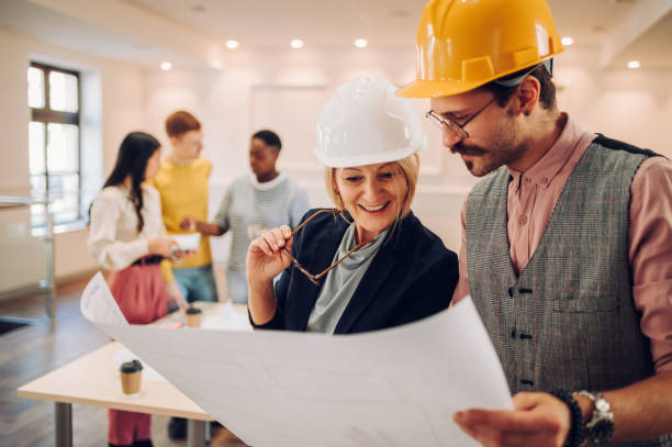 istock Portrait of two architect looking at blueprints in an office 1456061038
