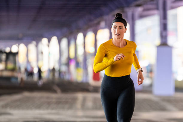 подтянутая женщина наслаждается своим регулярным бегом в нью-йорке - east river audio стоковые фото и изображения