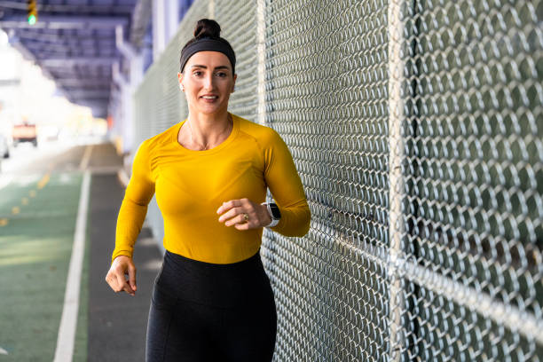 une femme en forme profite de sa séance de course régulière à new york - east river audio photos et images de collection