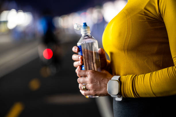 gros plan des mains d’une femme tenant une bouteille d’eau - east river audio photos et images de collection