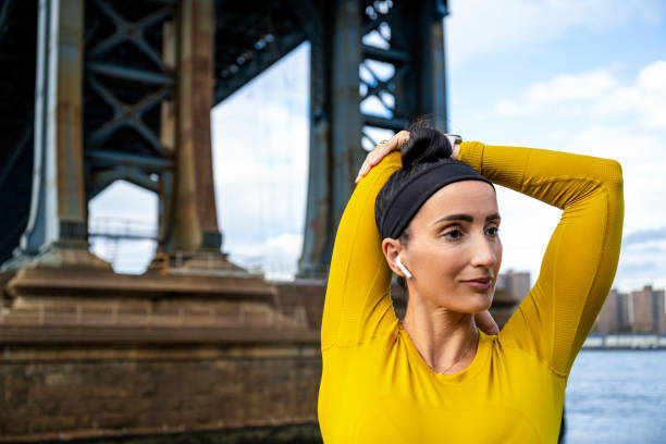 portrait of a beautiful woman stretching in new york - east river audio imagens e fotografias de stock