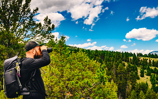 Man uses binoculars at scenic viewpoint