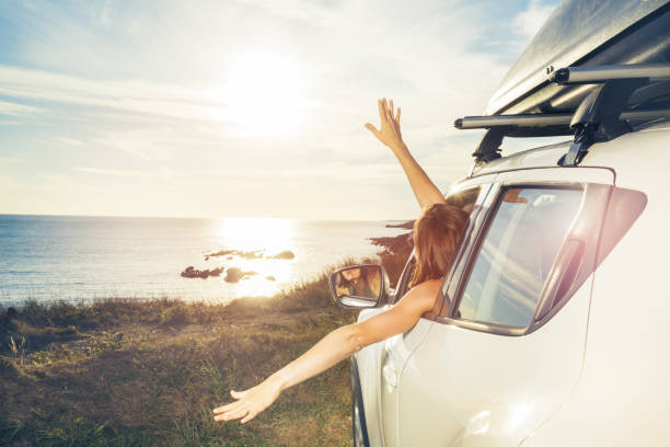 istock Woman on ocean parking relaxed wave hands from car window 1456068095