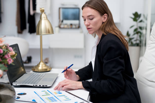 istock Woman works with a laptop in her home office while sitting at her desk 1456068367