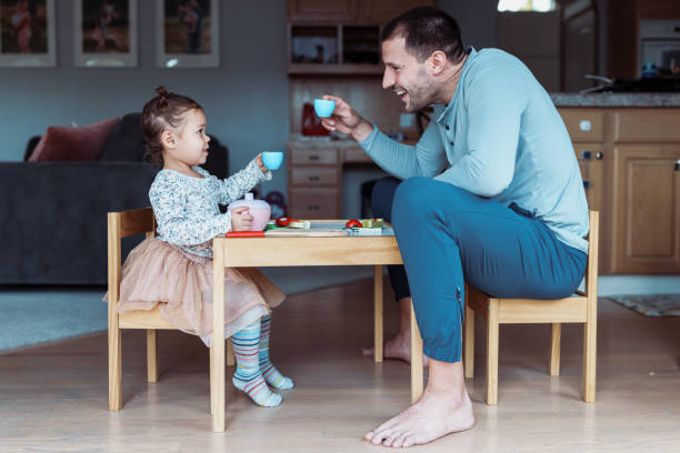 kleinkind mädchen und papa toast während der teeparty - childhood lifestyles caucasian expressing positivity stock-fotos und bilder