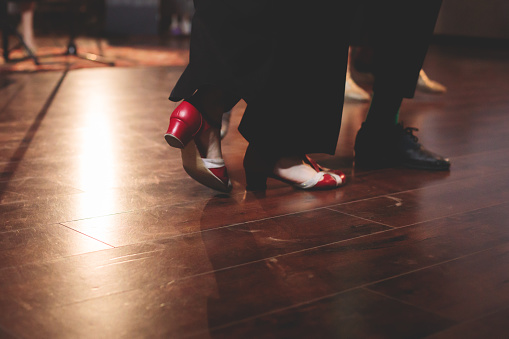 Dancing shoes of young couple dance retro jazz swing dances on a ballroom club wooden floor, close up view of a shoes, female and male, dance lessons class rehearsal