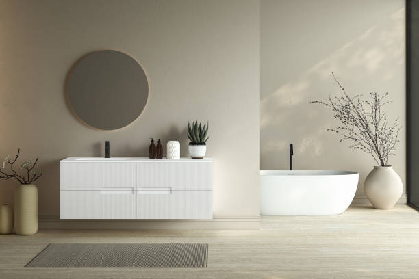 istock Bright minimal bathroom interior with white basin and oval mirror, bathtub, dry plants in vase, carpet on granite floor. Bathing accessories and window in hotel studio. 3D rendering 1456069606