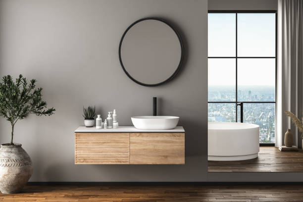 istock Modern bathroom interior with dark brown parquet floor, white oval bathtub and two sinks, front view. Minimalist bathroom with modern furniture and city view. 3D rendering 1456070379
