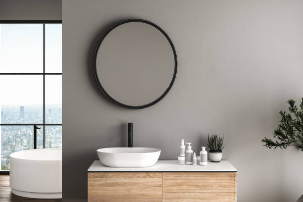 istock Modern bathroom interior with dark brown parquet floor, white oval bathtub and two sinks, front view. Minimalist bathroom with modern furniture and city view. 3D rendering 1456070384
