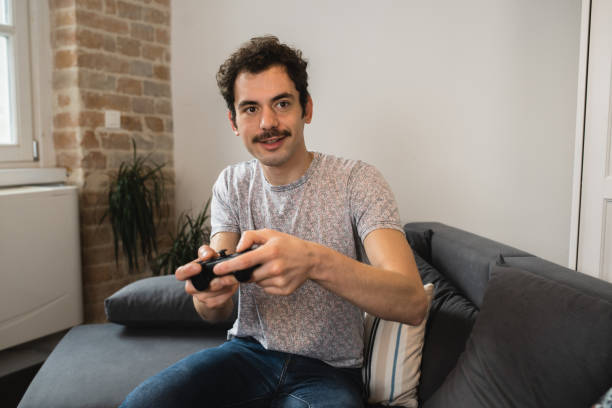 istock Young man gaming and having fun at home 1456070599