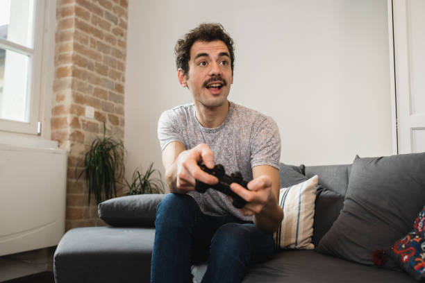 istock Young man gaming and having fun at home 1456070610