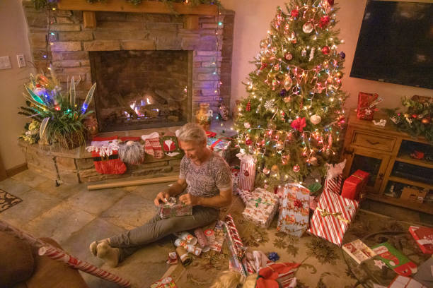 istock Senior man wraps presents under Christmas tree 1456072341