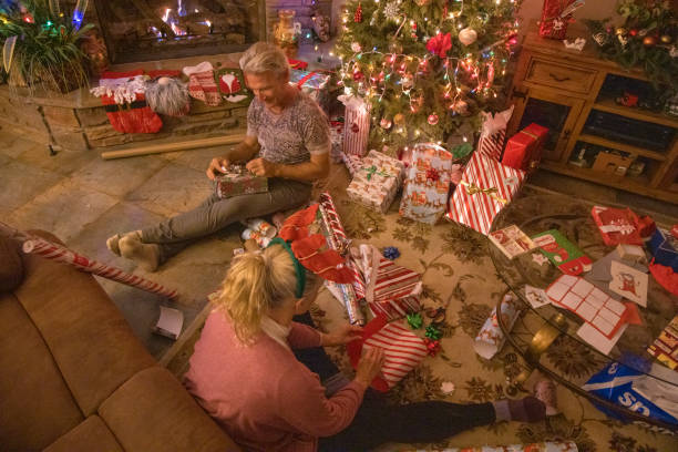 istock Senior couple wrap presents under Christmas tree 1456072372