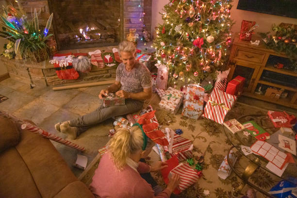 istock Senior couple wrap presents under Christmas tree 1456072417