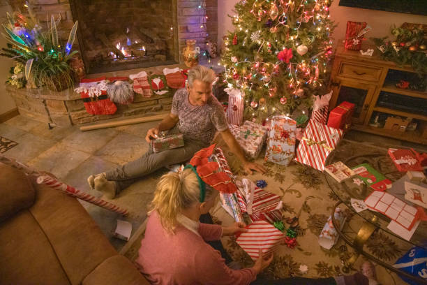 istock Senior couple wrap presents under Christmas tree 1456072488