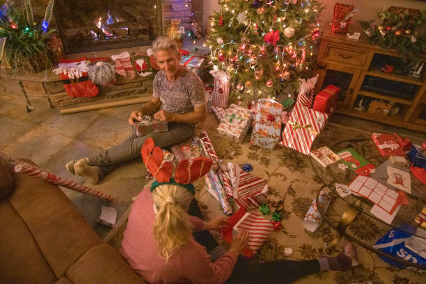 istock Senior couple wrap presents under Christmas tree 1456072490