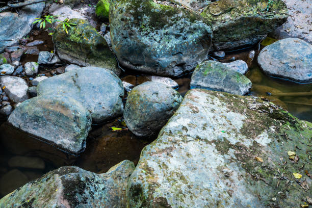 Rock with water flowing in Sapan waterfall, Thailand.