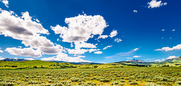 Panoramic mountain view. Rocky desert and blue sky with white clouds.