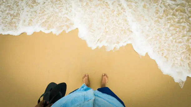 first person view of the feet in an area with sea water