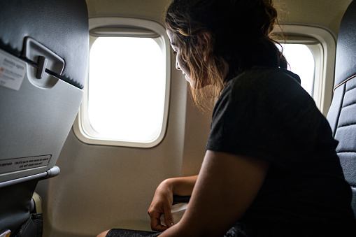 Woman looking out of airplane window