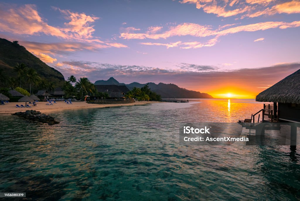 Sunset over tranquil bay and mountains Bungalow in harbour Aerial View Stock Photo