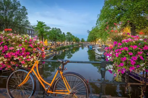 Photo of Scenic view of a beautiful canal and a bicycle on a bridge in Amsterdam
