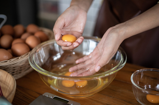 Hands woman separating the yolks from the whites.