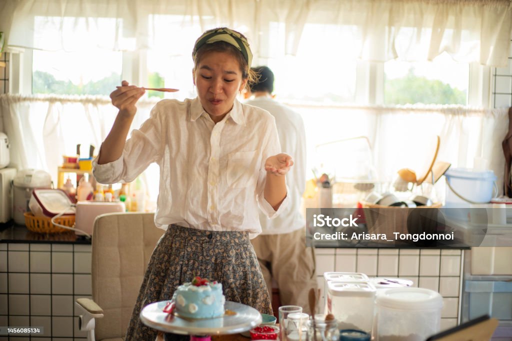 The woman tasted the cake she made and was amazed at how delicious it was. 16-17 Years Stock Photo