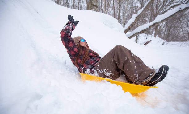 istock A woman riding a snow sled down a hill 1456085913